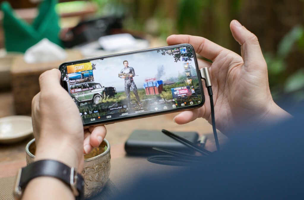 Person playing a mobile game on a smartphone, illustrating AI-generated mini-game apps.